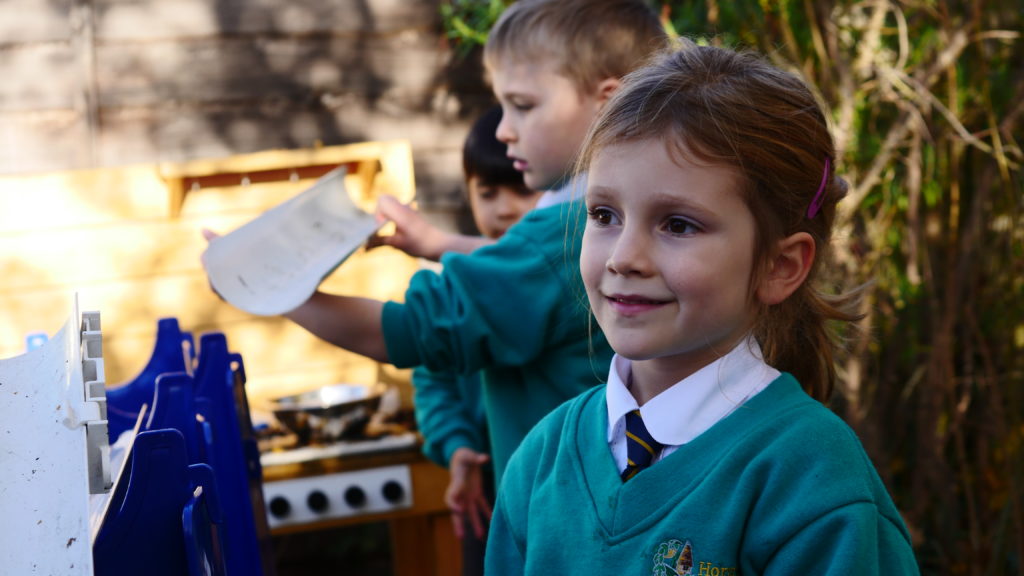 A girl smiling while looking into the distance on the playground