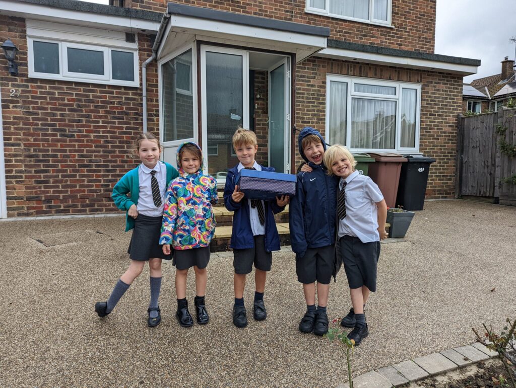 5 children holding a harvest box