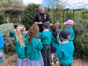 A group of young pupils from Years 1 and 2 are pictured gathered around a member of staff who is speaking to them, during a school trip to Kent Life.